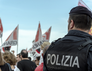 Policeman in front of protesters against cruise ships in Venice
